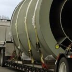 Semi-truck hauling oversized cylindrical pipe