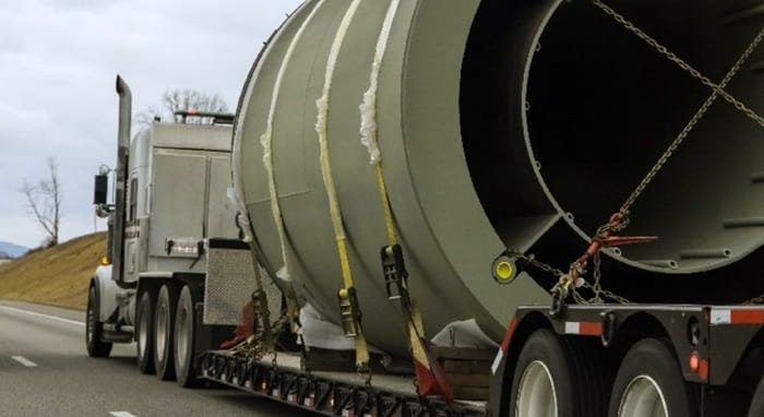 Semi-truck hauling oversized cylindrical pipe